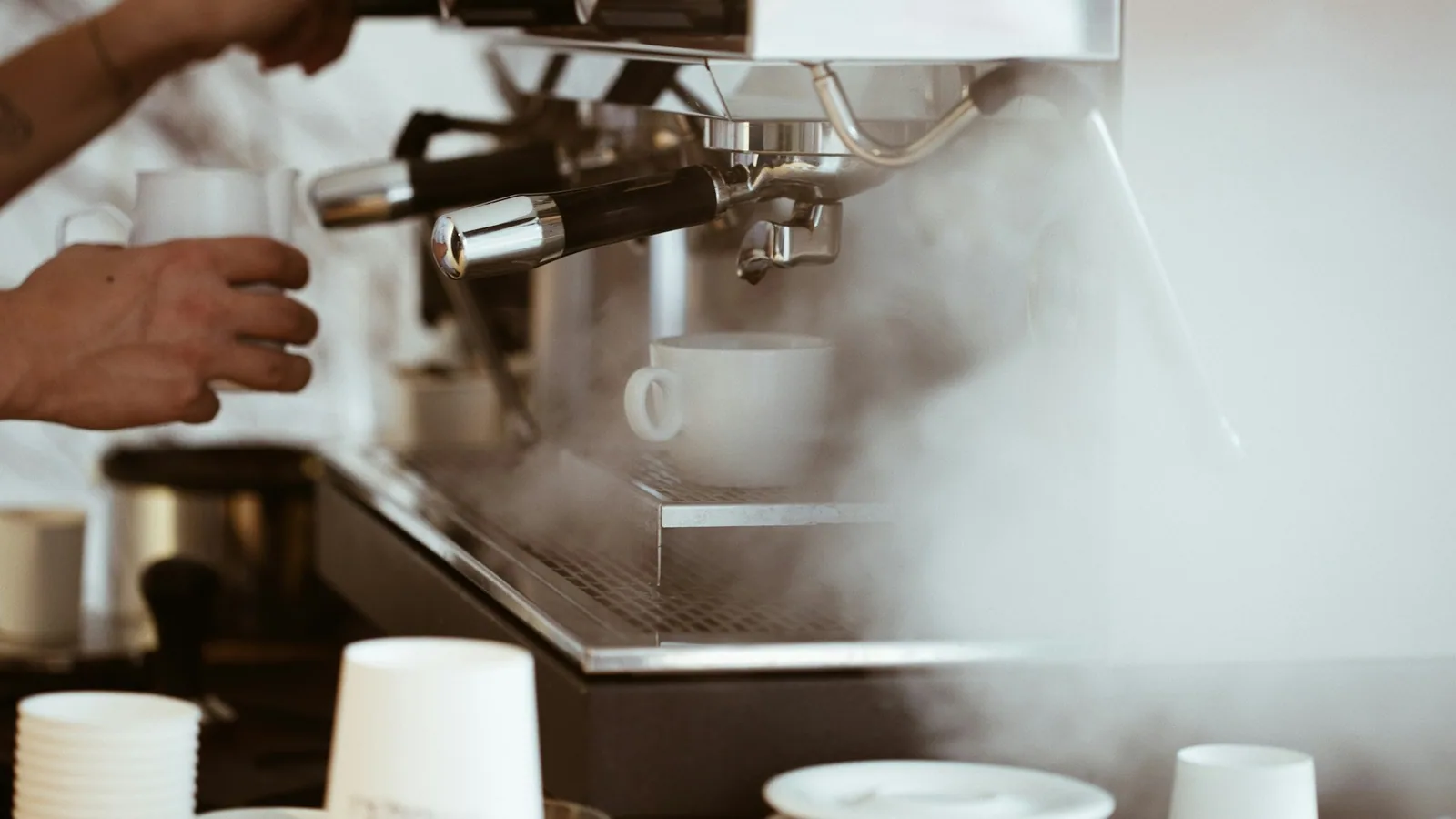 Client scannant son smartphone devant un barista à la machine, ambiance matin dans un café-torréfacteur indépendant.