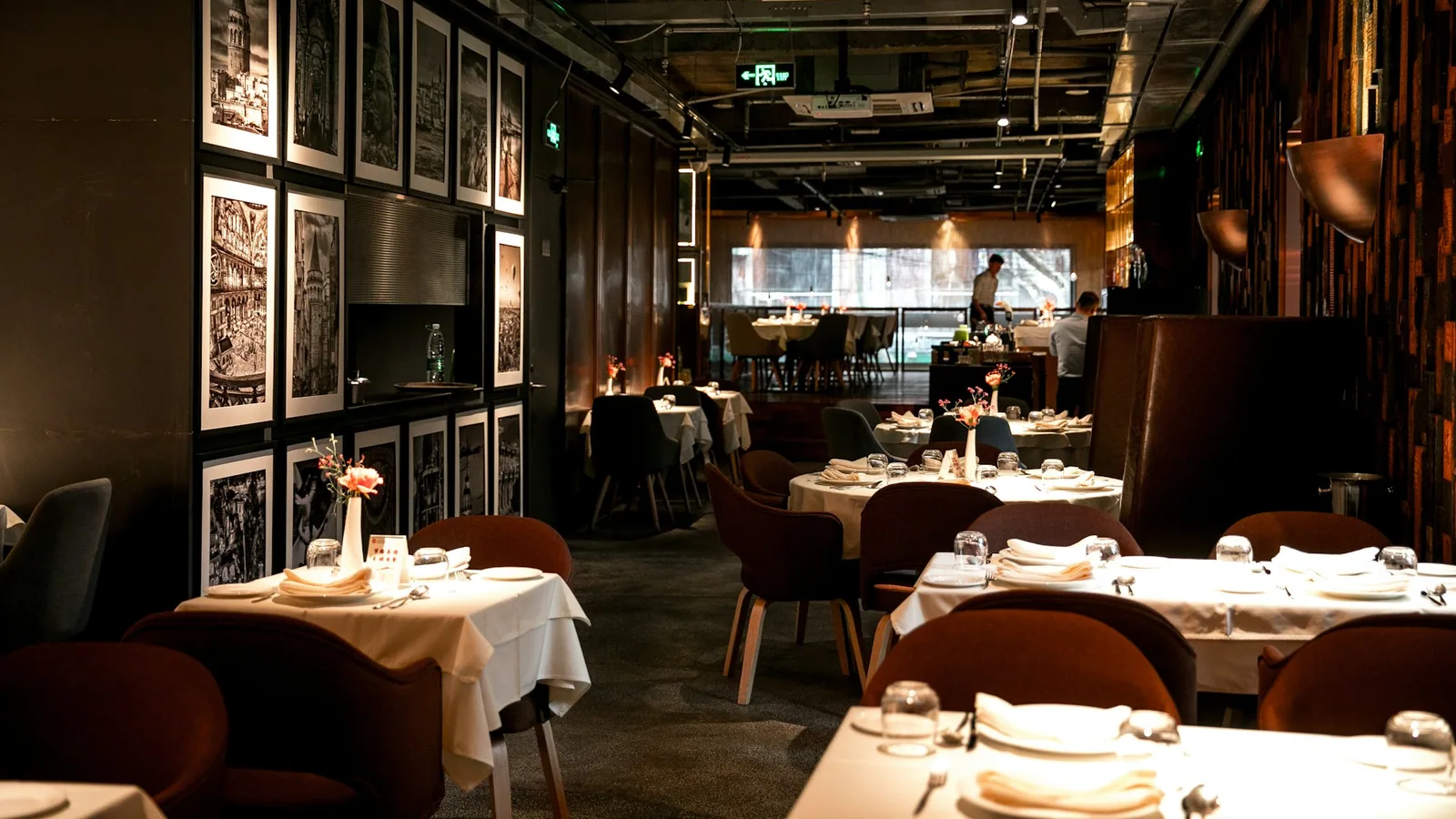 Carte posée sur une table de restaurant avec un smartphone affichant une recherche Google Maps, lumière chaude en soirée.
